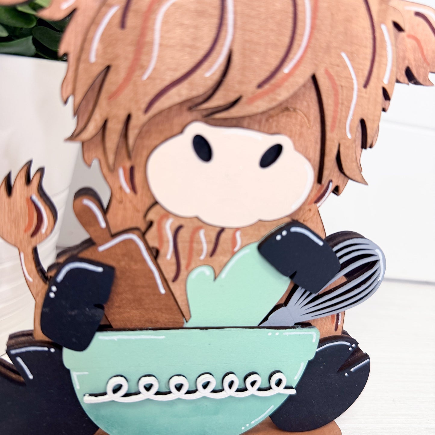 cow with a bowl and kitchen utensils on a white background