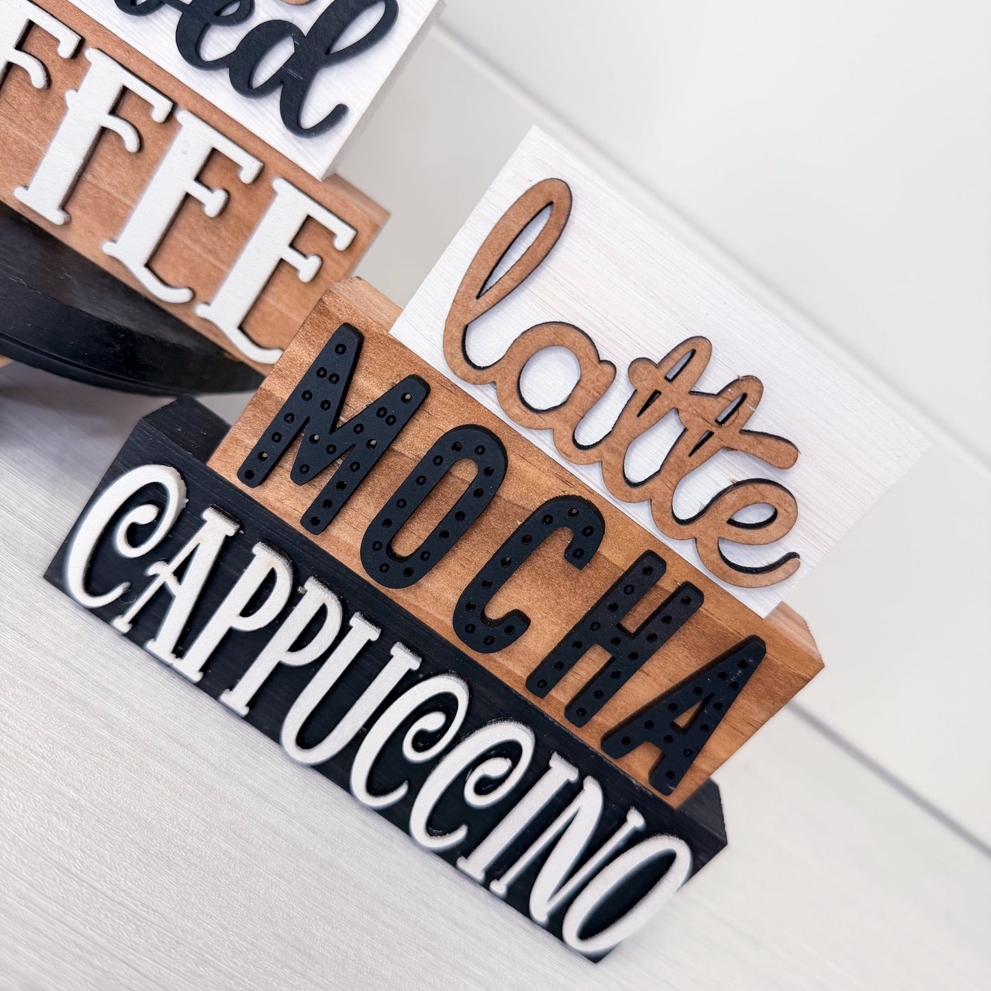 Wooden signs with coffee-related text on a light background