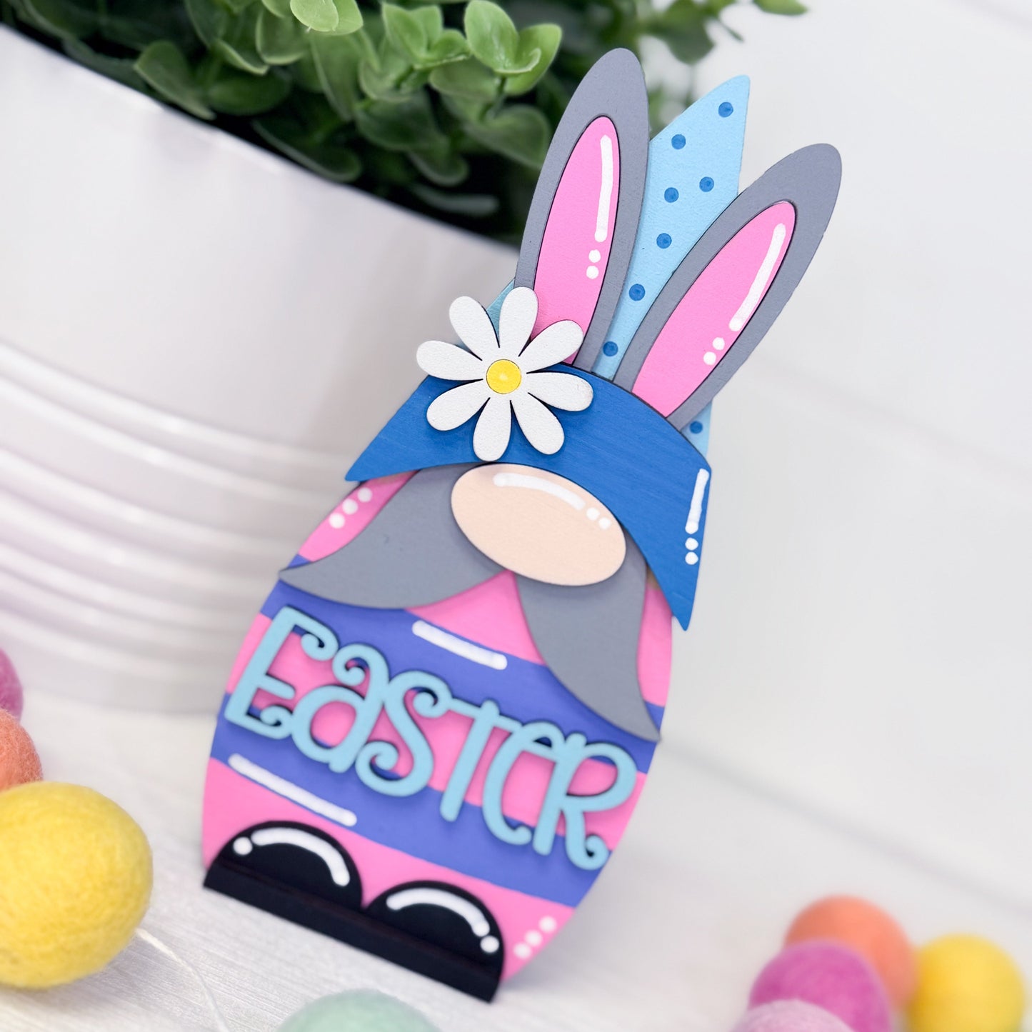 Colorful Easter gnome with bunny ears and 'Easter' text on a white background