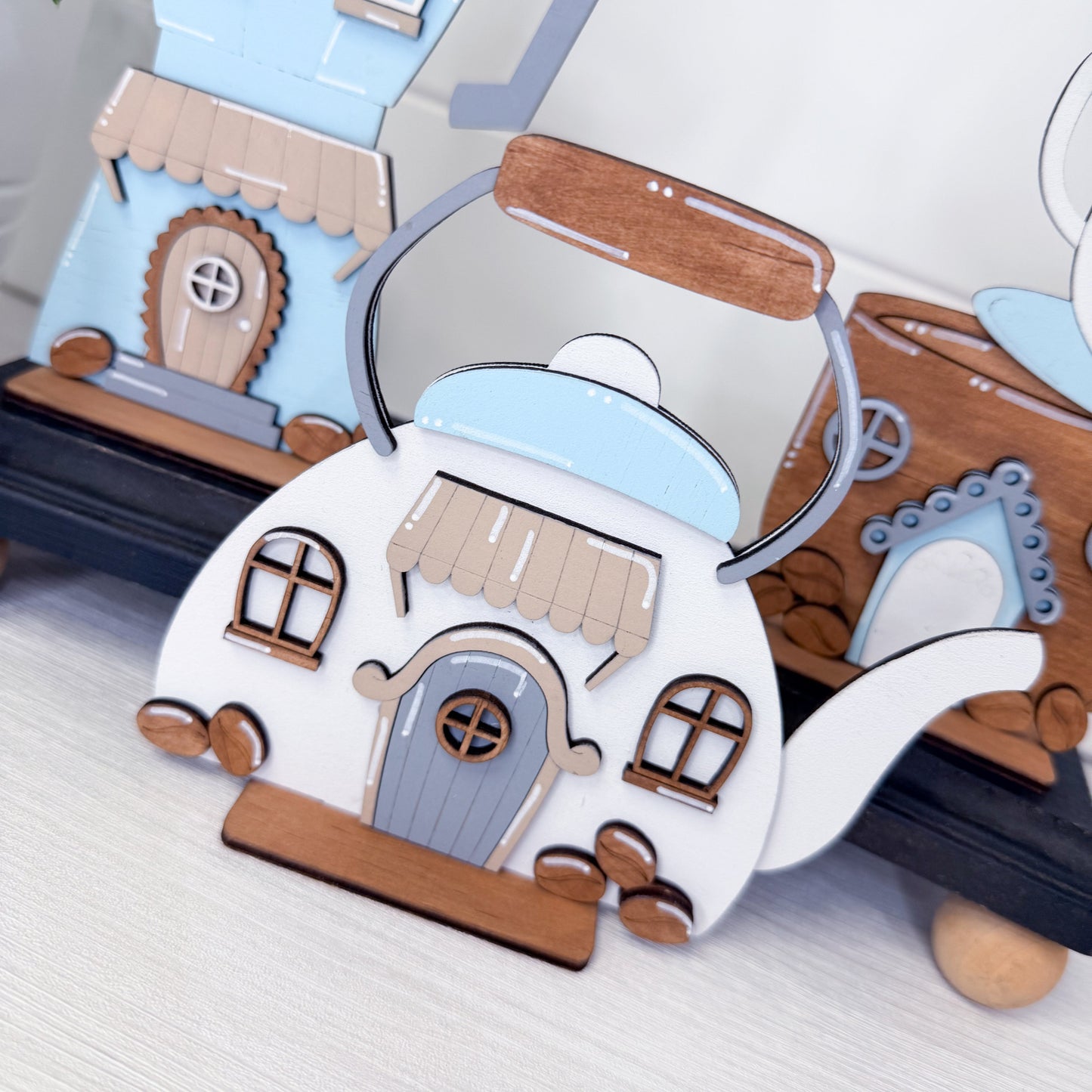 Decorative house-shaped coffee pots on a white surface