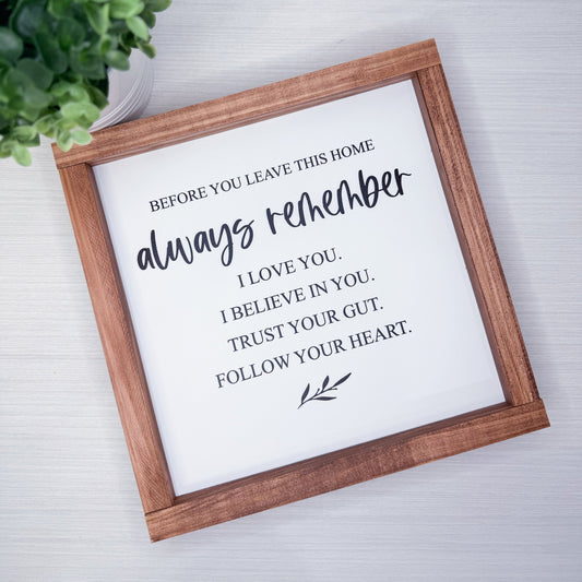 Wooden-framed sign with motivational quote on a light background