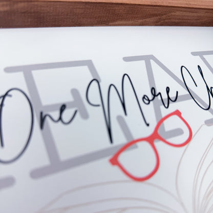 Decorative sign with 'One More Chance' text and red glasses graphic on a white background.
