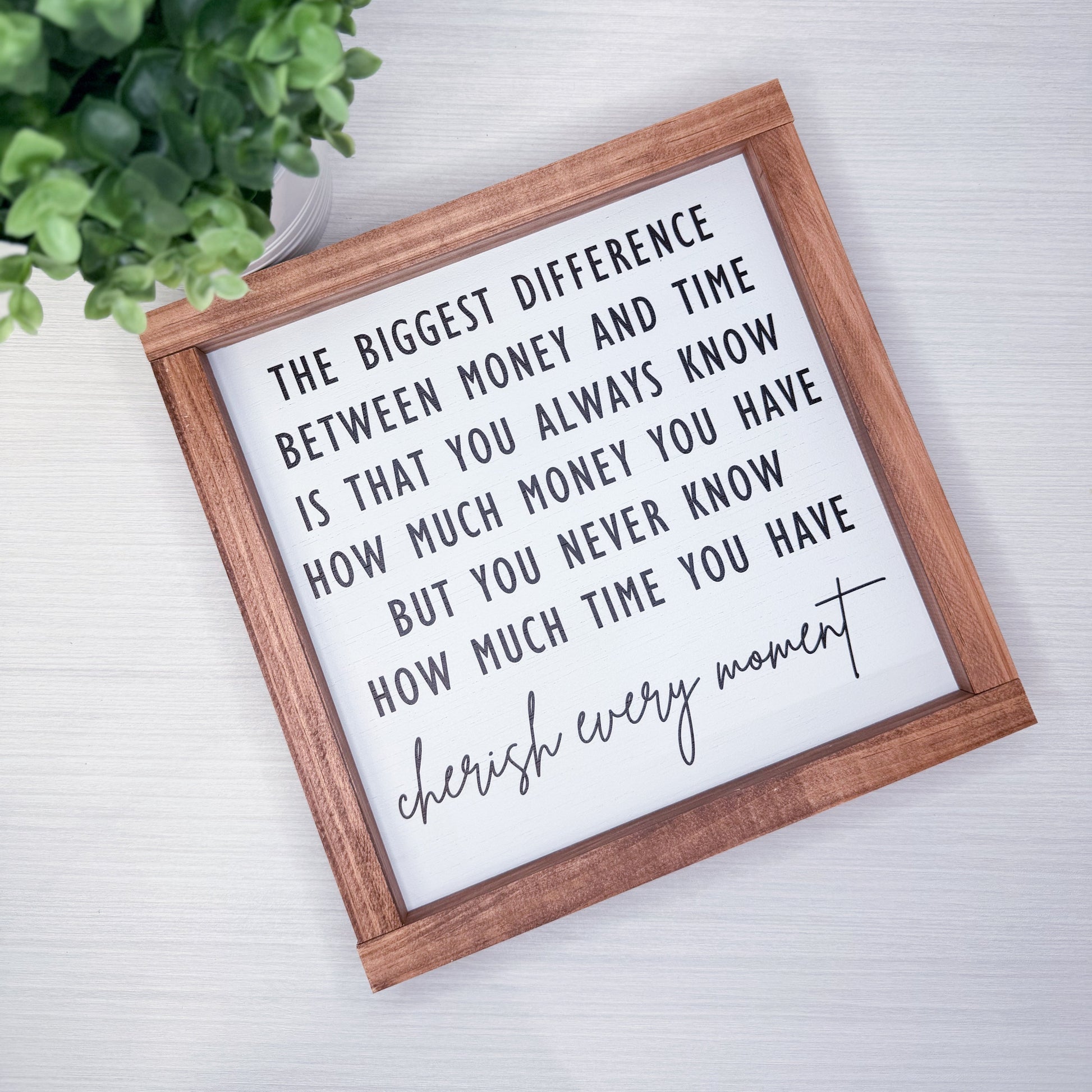 Framed quote on a white background with a plant to the left