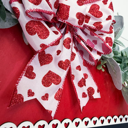 Decorative bow with red heart pattern on a red background