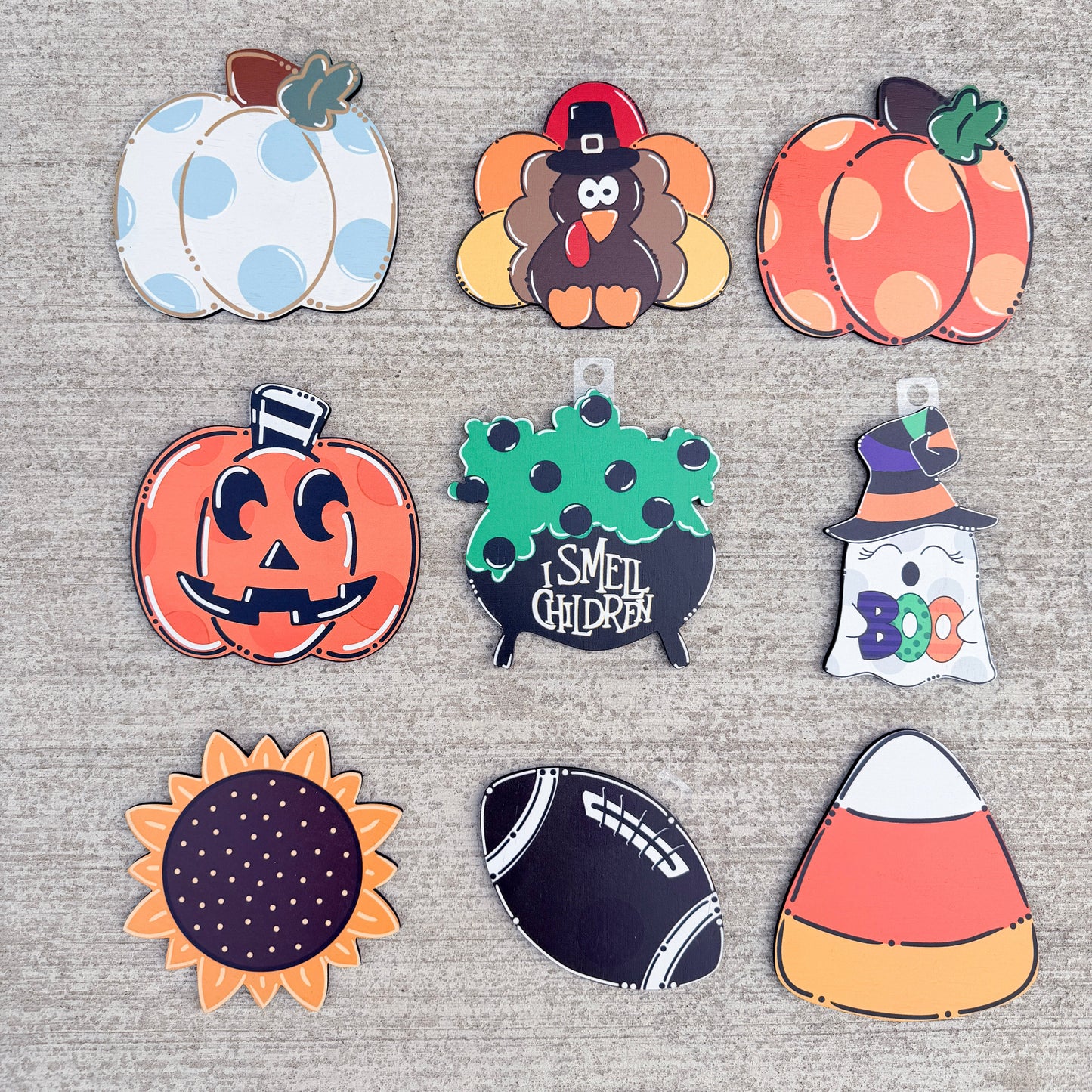 The designs include three pumpkins, a turkey, two jack-o'-lanterns, a ghost, a candy corn, a football, and a sunflower with a purple polka-dot center.