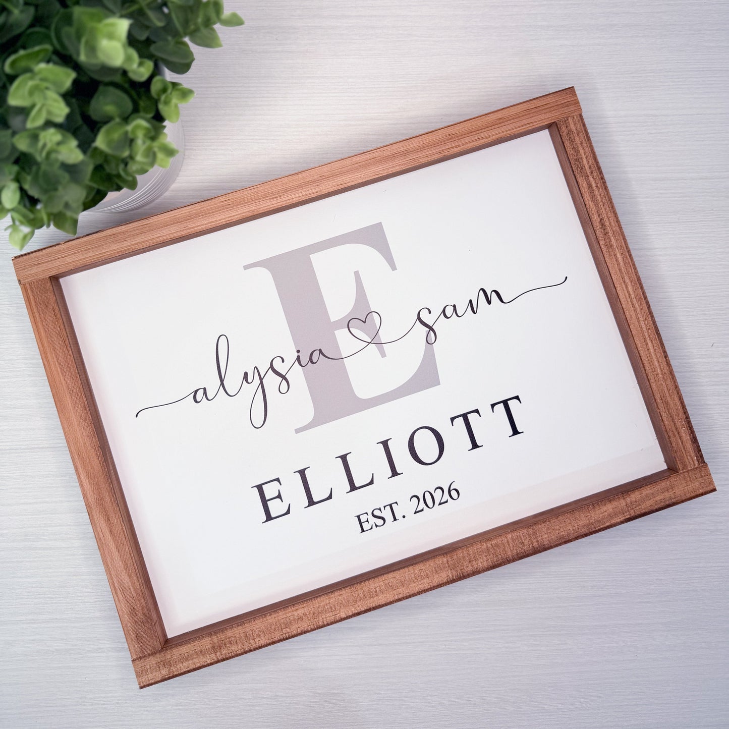 Framed print with 'Elyasia & Sam Elliott EST. 2026' on a light background