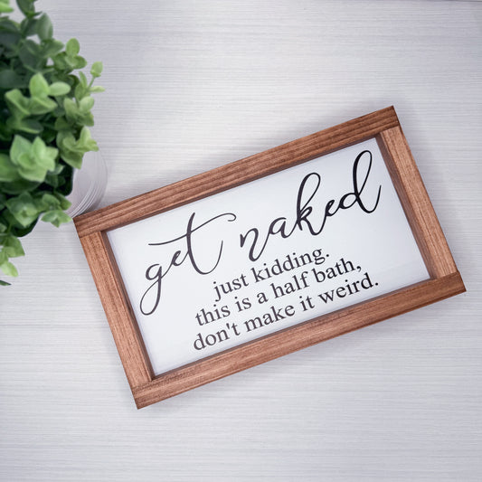 Wooden-framed sign with humorous text on a white background