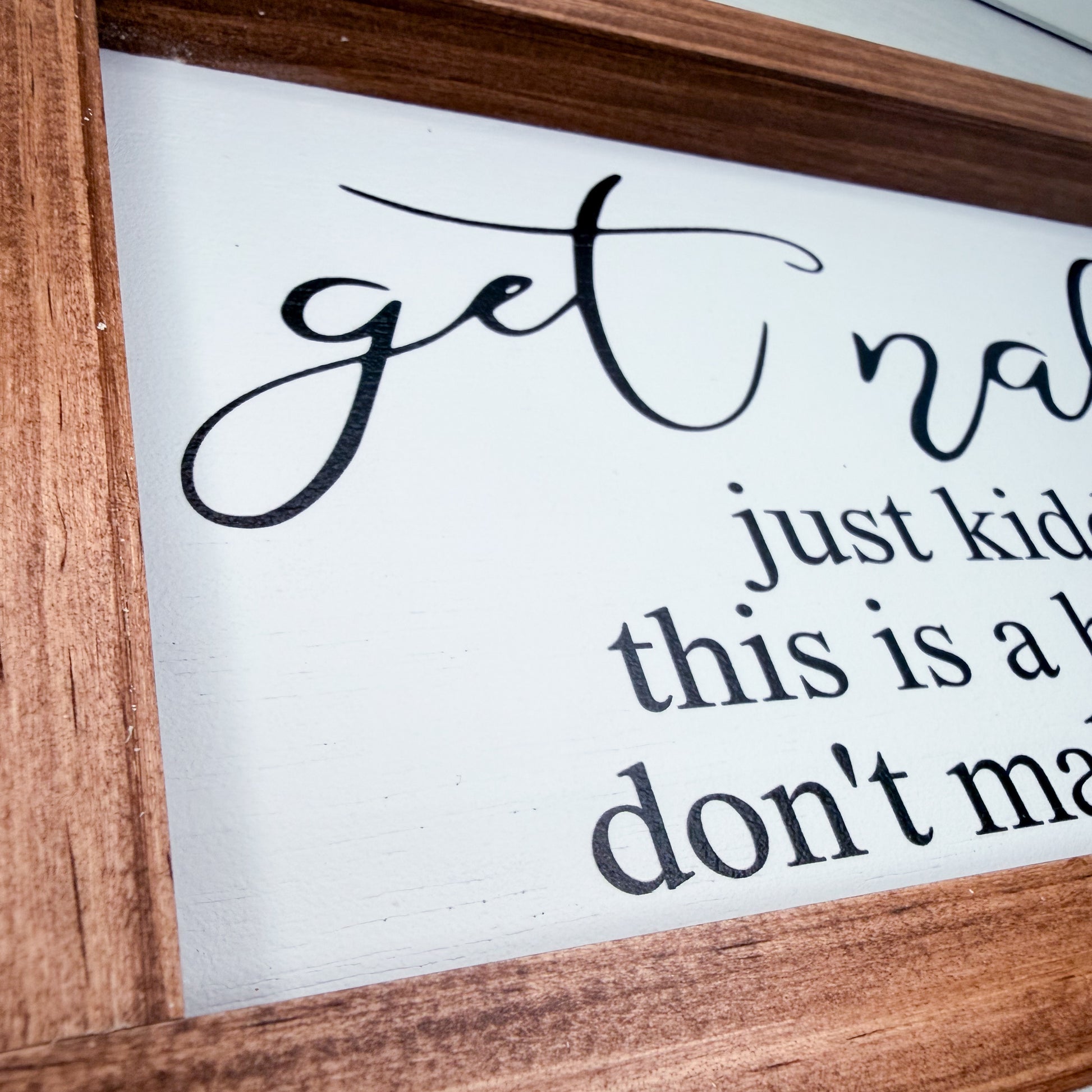 Wooden-framed sign with text on a white background