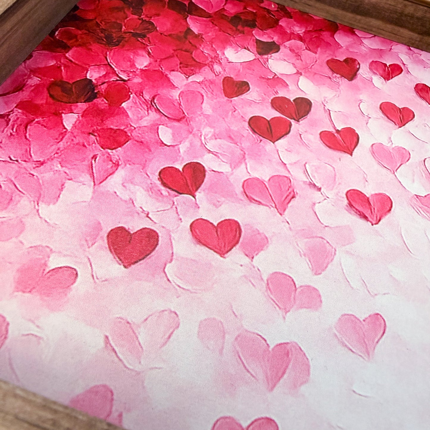 Pink and red heart-shaped confetti on a pink background