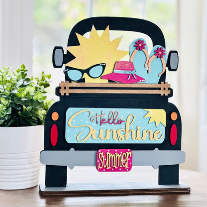 A decorative wood insert featuring a colorful illustration of a sun wearing sunglasses and a hat, with text that reads 'Hello Sunshine' and 'Summer'. The piece is designed to be interchangeable and is part of a seasonal home decor set.