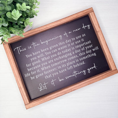 Motivational quote on a framed chalkboard with a wooden frame, placed on a light surface with a plant in the corner.