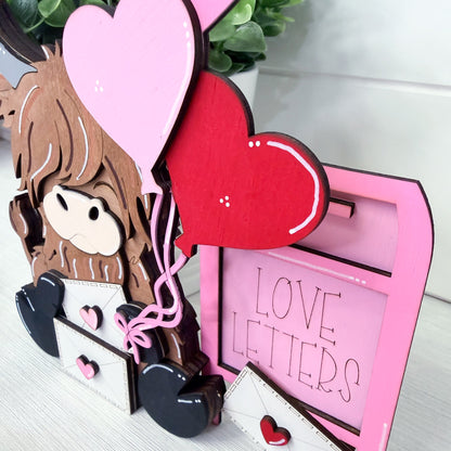 Decorative item with cartoon character, heart-shaped elements, and 'LOVE LETTERS' frame on a light background.