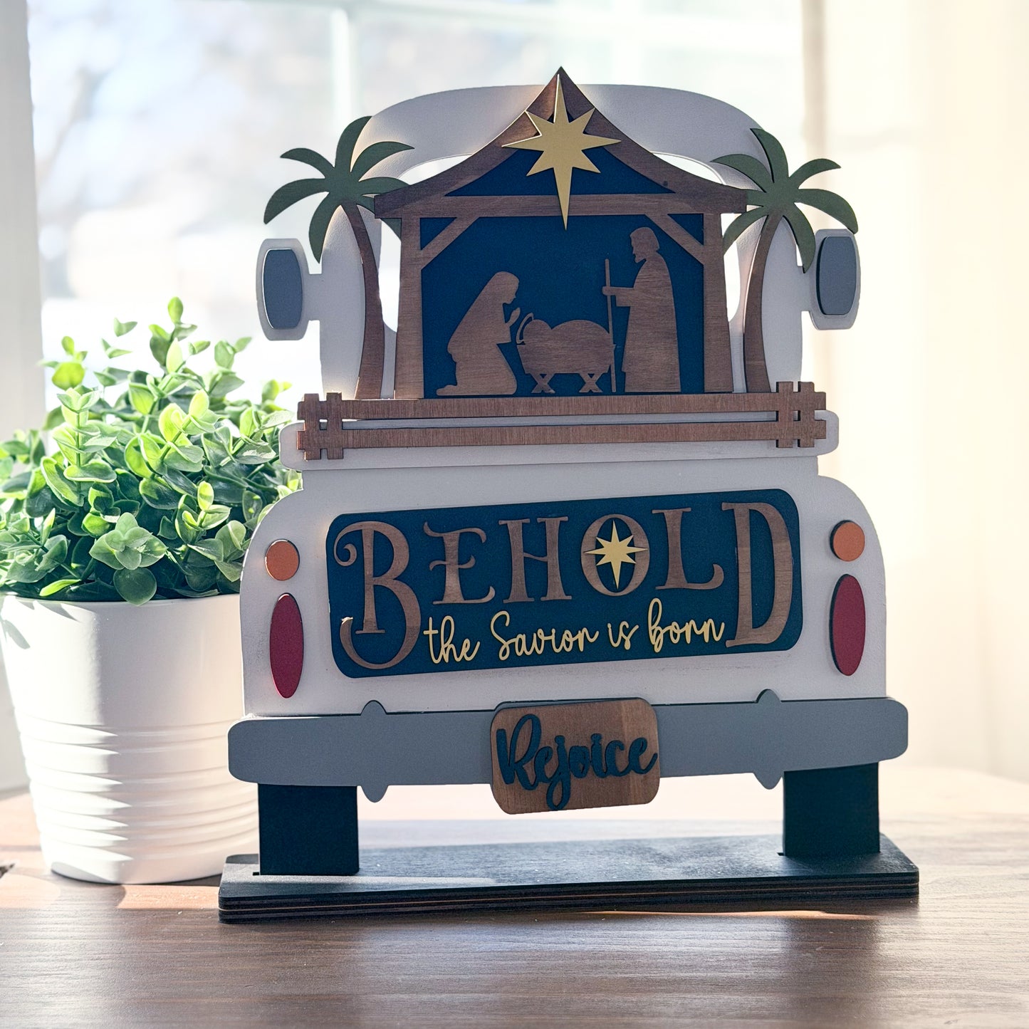Decorative nativity scene with 'Behold the Saviour is Born' text on a vehicle model.