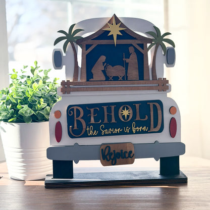 Decorative nativity scene with 'Behold the Saviour is Born' text on a vehicle model.