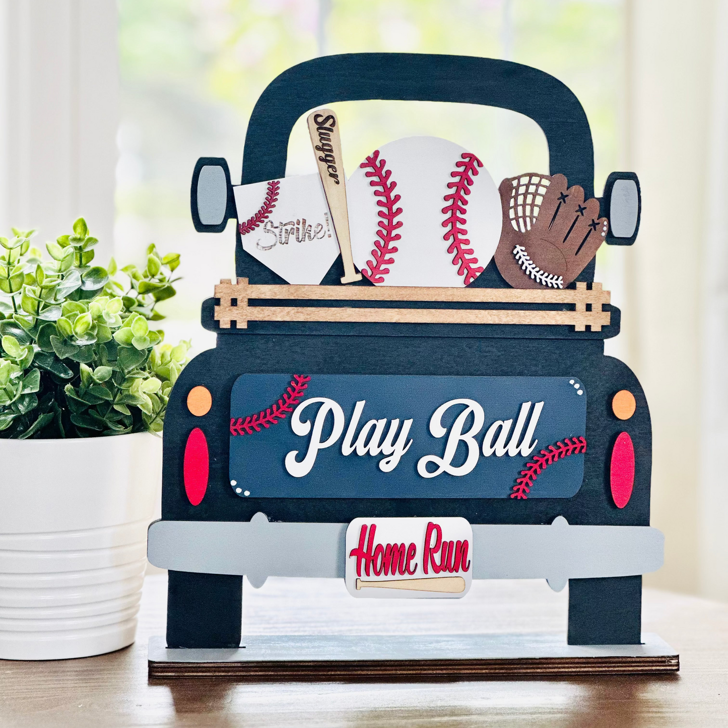 A decorative wood truck with interchangeable baseball-themed insert pieces, including a baseball and a bat, with the phrases 'Play Ball' and 'Home Run' on it.