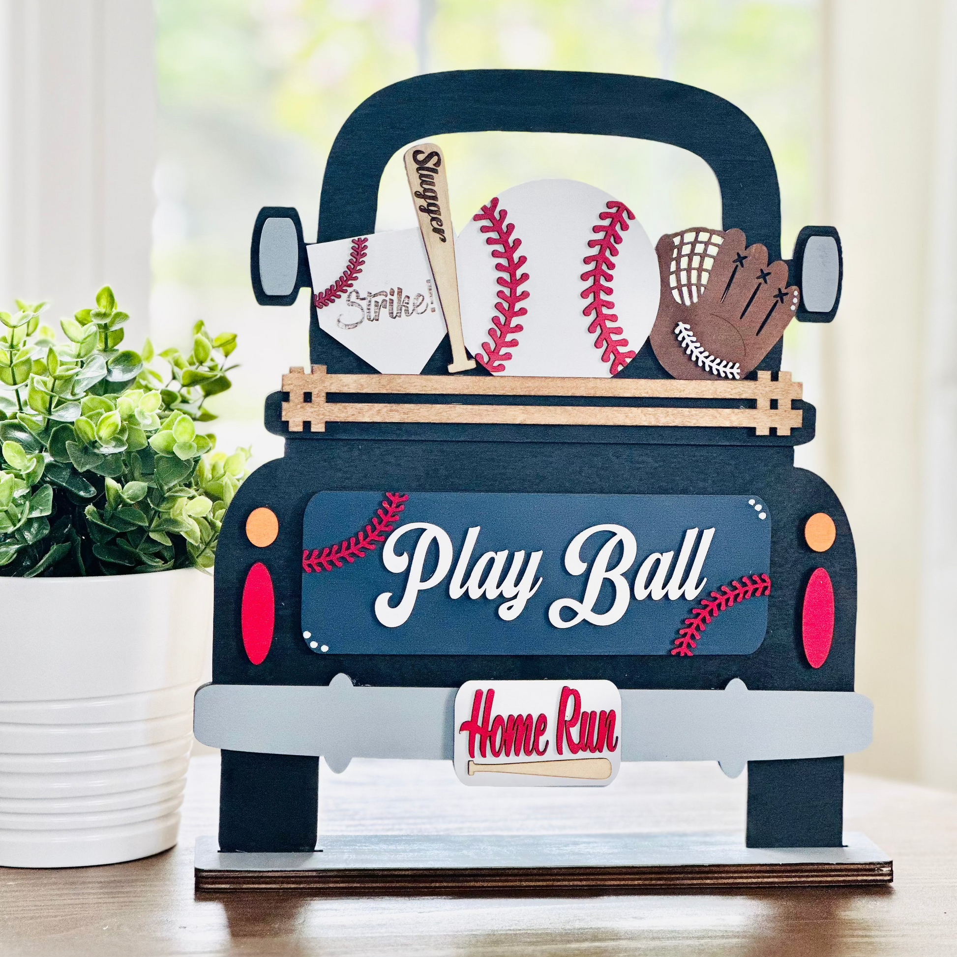 A decorative wood truck with interchangeable baseball-themed insert pieces, including a baseball and a bat, with the phrases 'Play Ball' and 'Home Run' on it.