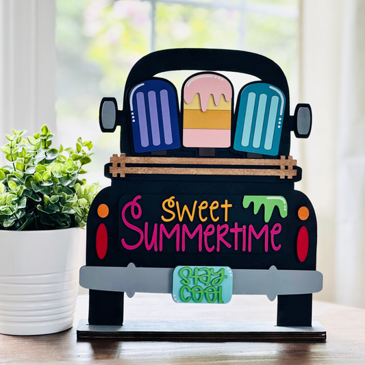 A decorative wood truck with interchangeable insert displaying the text 'Sweet Summertime' and various summertime-themed items.
