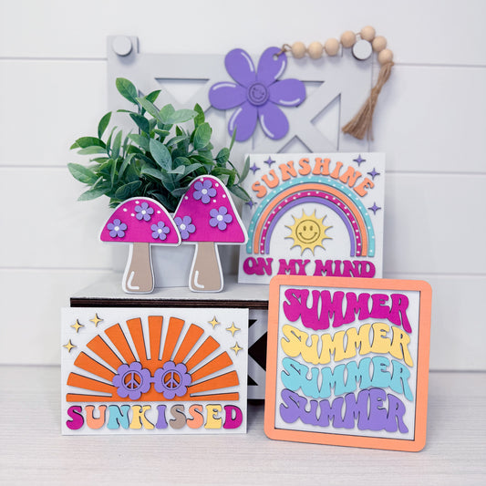 Decorative signs with colorful designs and text on a white wooden background