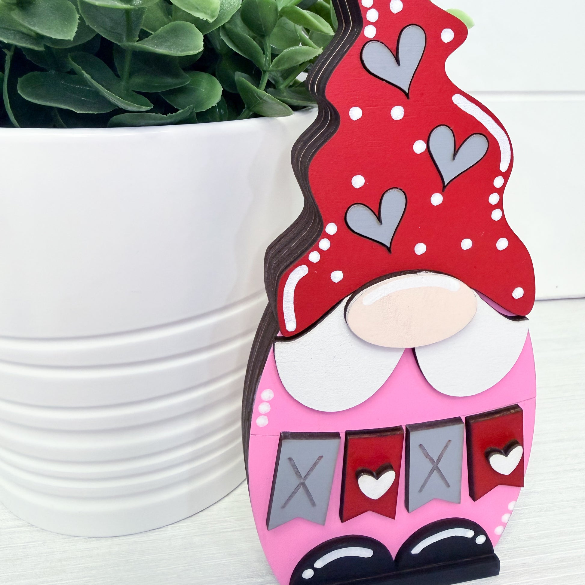 Valentine-themed wooden gnome with red hat and pink body, hearts, and 'XOXO' text, against a white background.