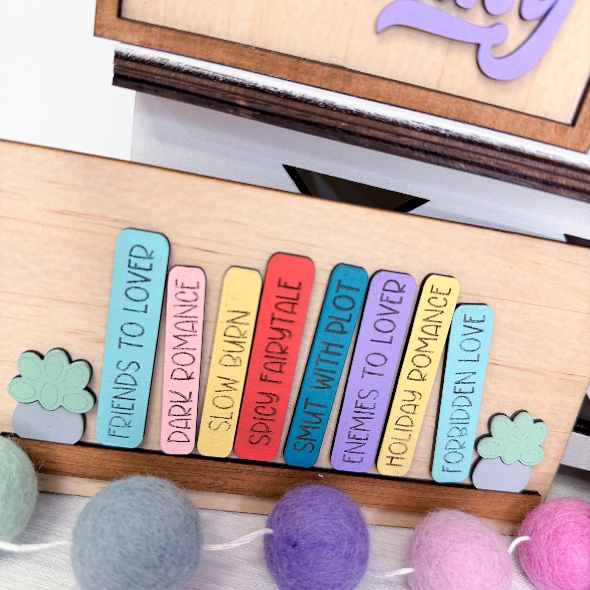 Colorful bookmarks with text on a wooden board with decorative elements.