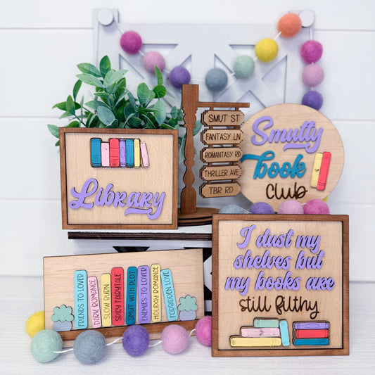 Decorative wooden signs with text and book illustrations on a white background