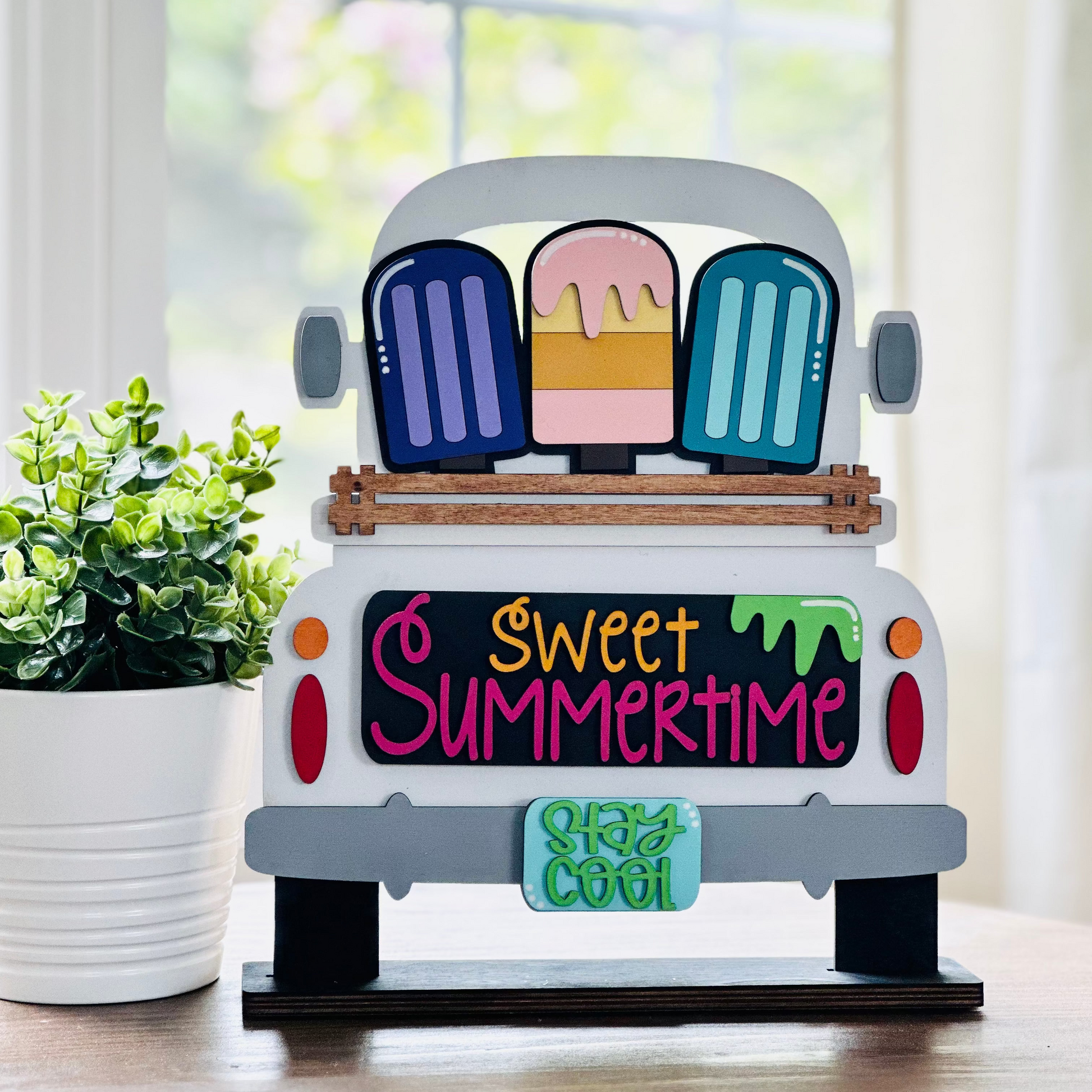 A decorative wood truck with interchangeable insert displaying the text 'Sweet Summertime' and various summertime-themed items.