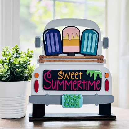 A decorative wood truck with interchangeable insert displaying the text 'Sweet Summertime' and various summertime-themed items.
