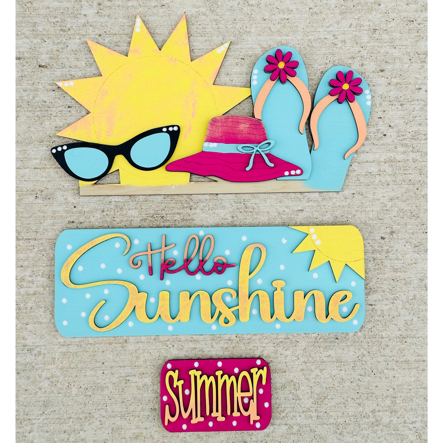A decorative wood insert featuring a colorful illustration of a sun wearing sunglasses and a hat, with text that reads 'Hello Sunshine' and 'Summer'. The piece is designed to be interchangeable and is part of a seasonal home decor set.