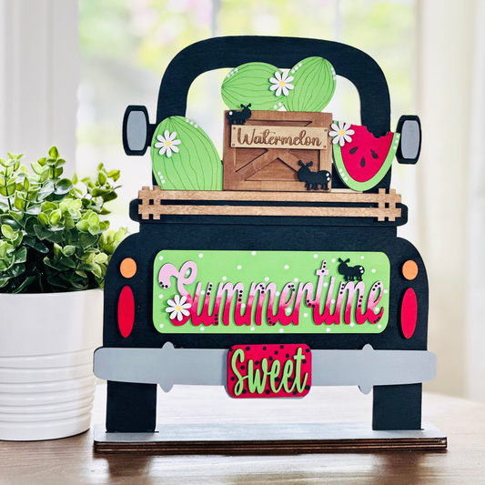 A wooden interchangeable sign with a truck design, green and red text, and illustrations of a cactus, melon, and flowers, titled 'Sweet Summer'.