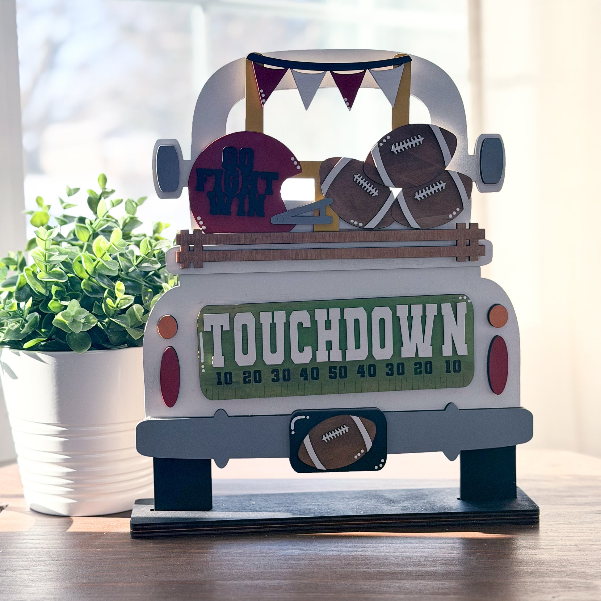 Decorative item resembling a truck with football-themed elements on a wooden surface.