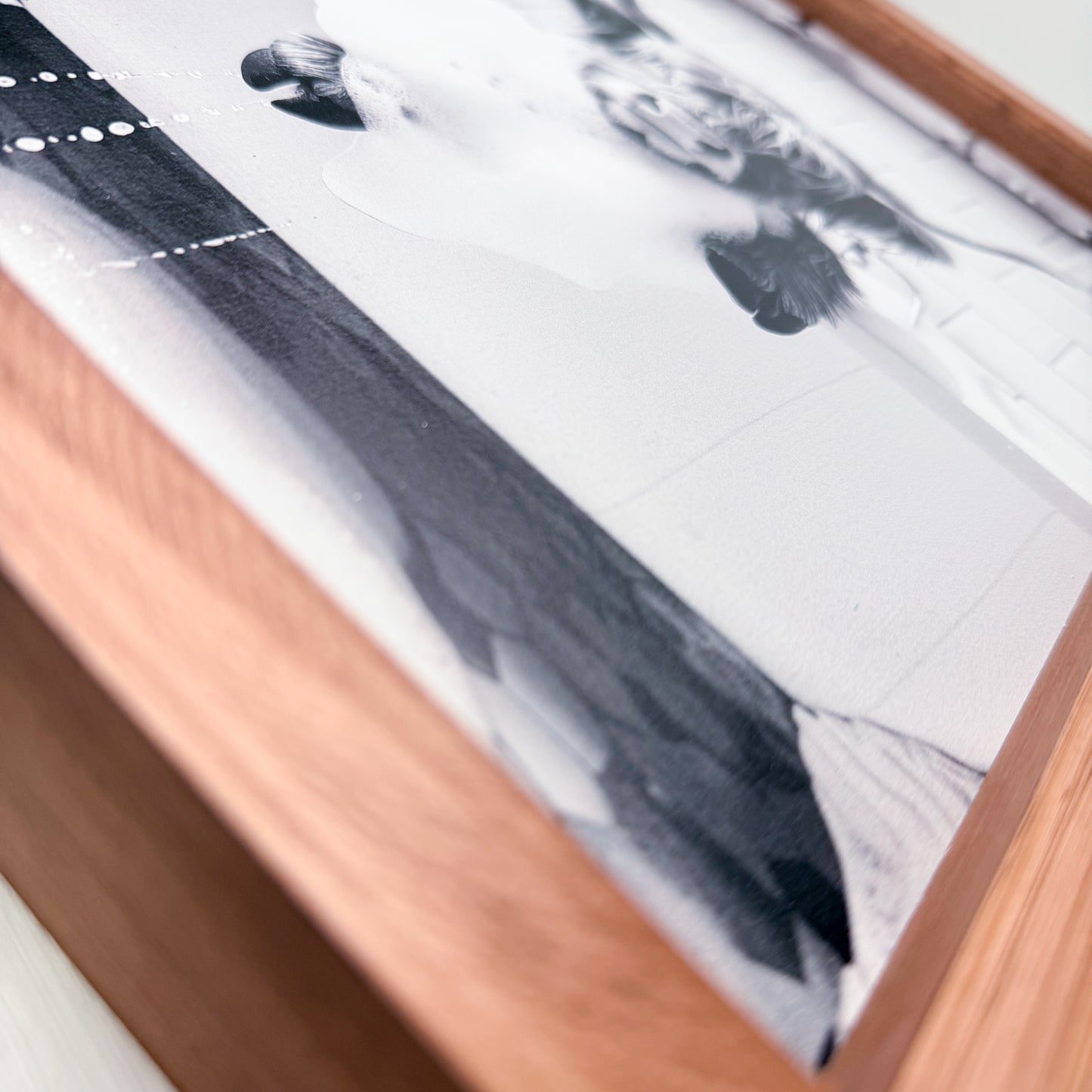Close-up of a framed black and white abstract artwork with a wooden frame.