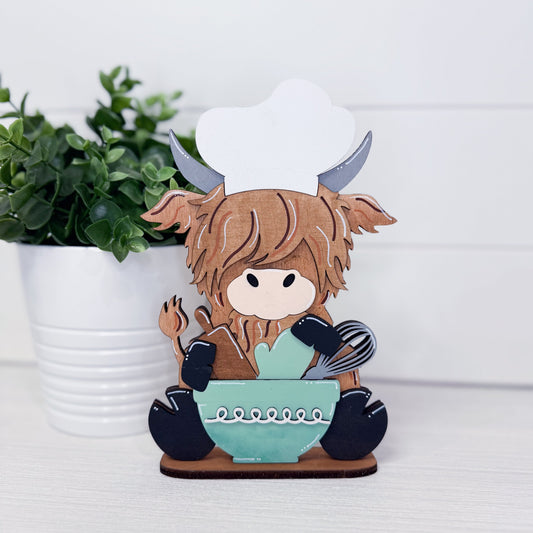 Decorative figurine of a character with horns and a chef's hat, sitting on a bowl.