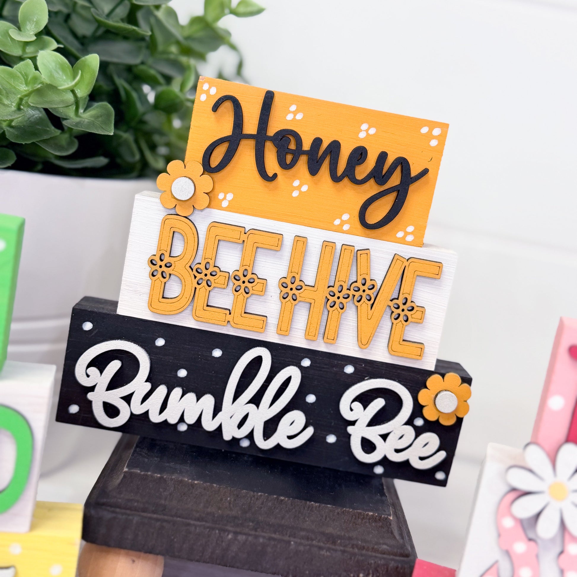 Decorative sign with 'Honey Bee Hive Bumble Bee' text on a stand.