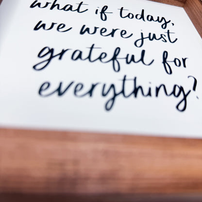 Handwritten text on a white sheet of paper with a wooden surface underneath.