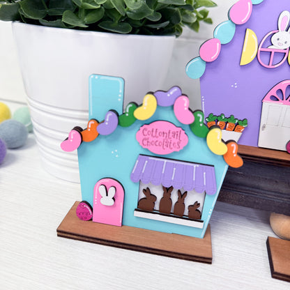 Colorful chocolate shop model with bunny figures on a white surface