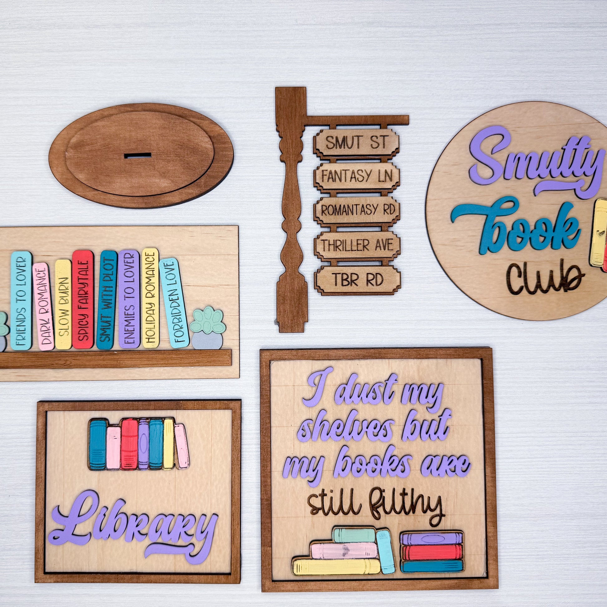 Collection of wooden signs with book-themed designs on a white background