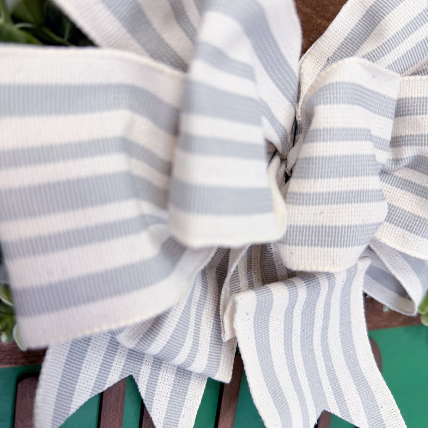 Close-up of a grey and white striped bow on a green background