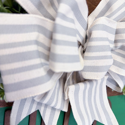 Close-up of a grey and white striped bow on a green background