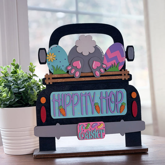 Decorative Easter jeep with colorful eggs and 'Hippity Hop Easter' text on a wooden surface.