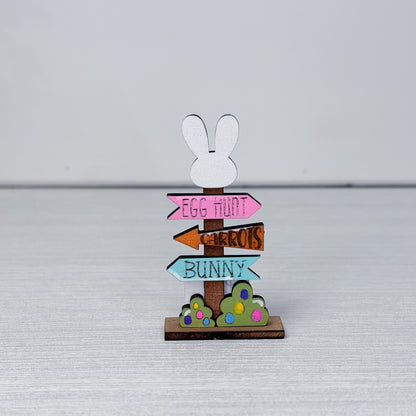 Decorative wooden sign with bunny design and colorful text on a light gray background