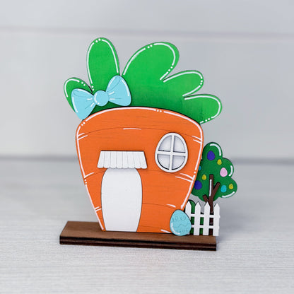 Carrot-shaped house with green leaves and a blue bow on a gray background
