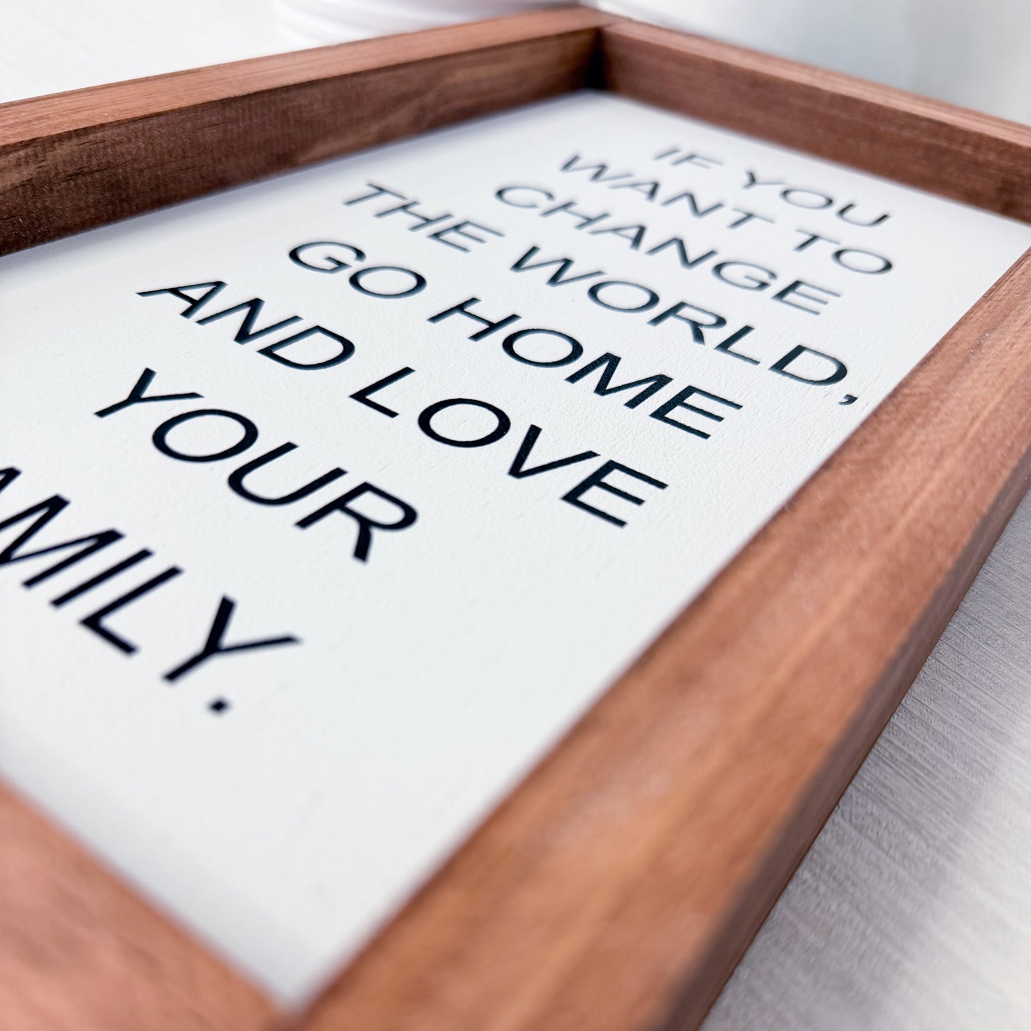 Wooden framed sign with motivational quote on a white background