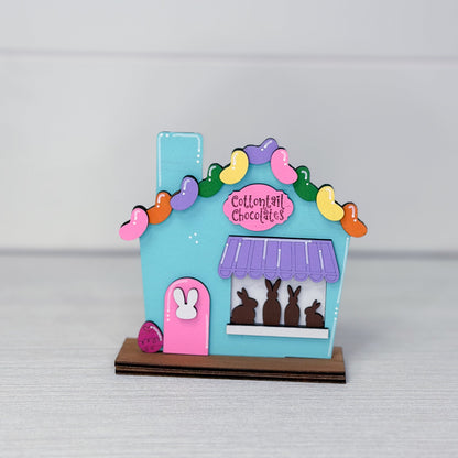 Colorful chocolate shop model with bunny figures on a gray background