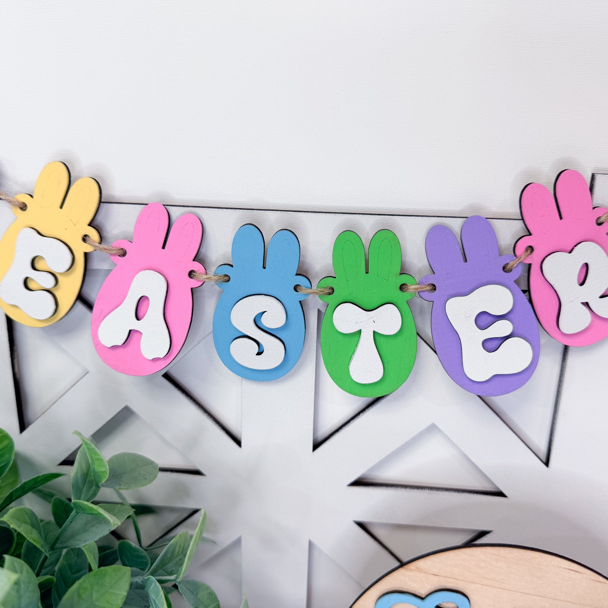 Colorful Easter banner with bunny shapes on a white wooden background
