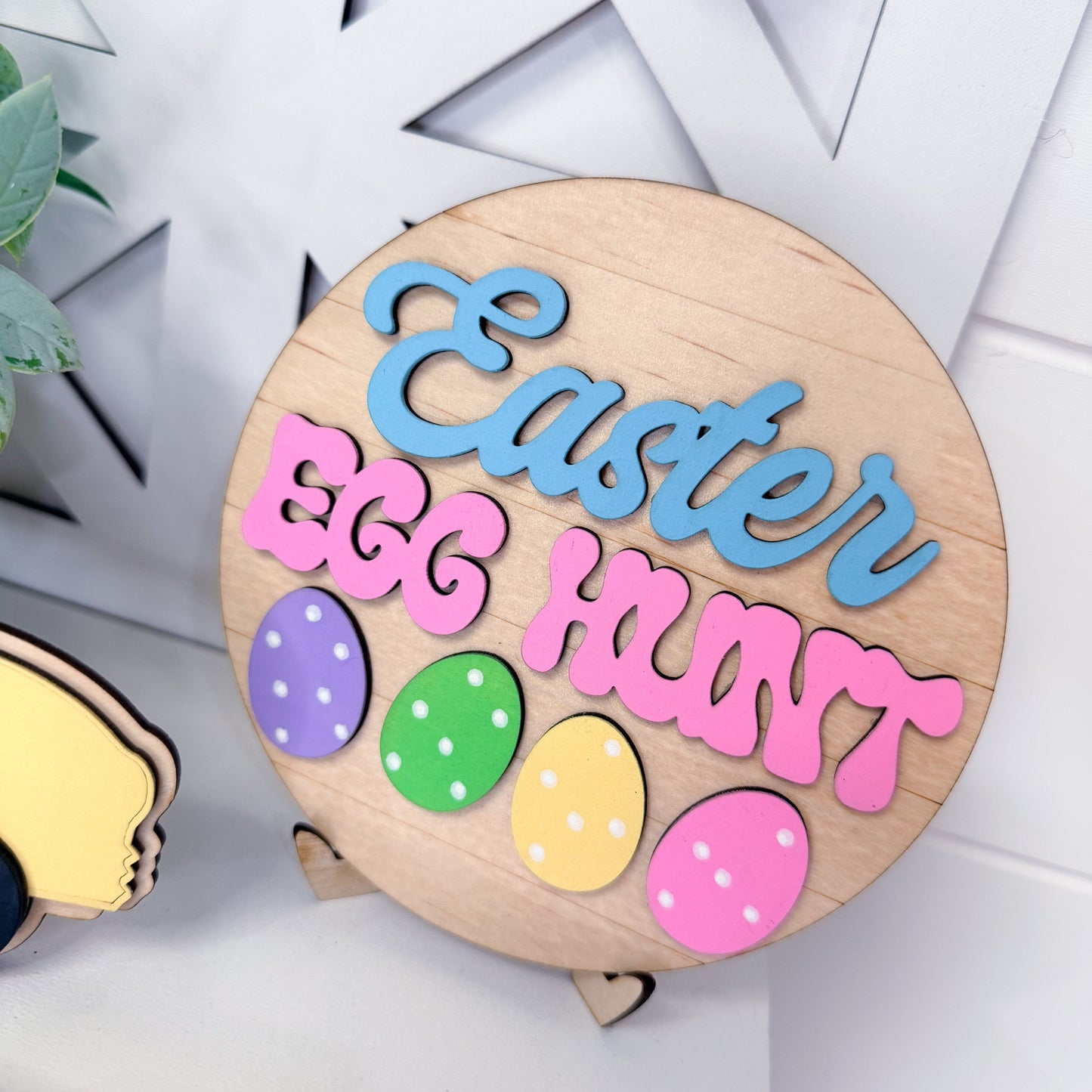 Wooden Easter sign with colorful eggs and 'Easter Egg Hunt' text on a white background.