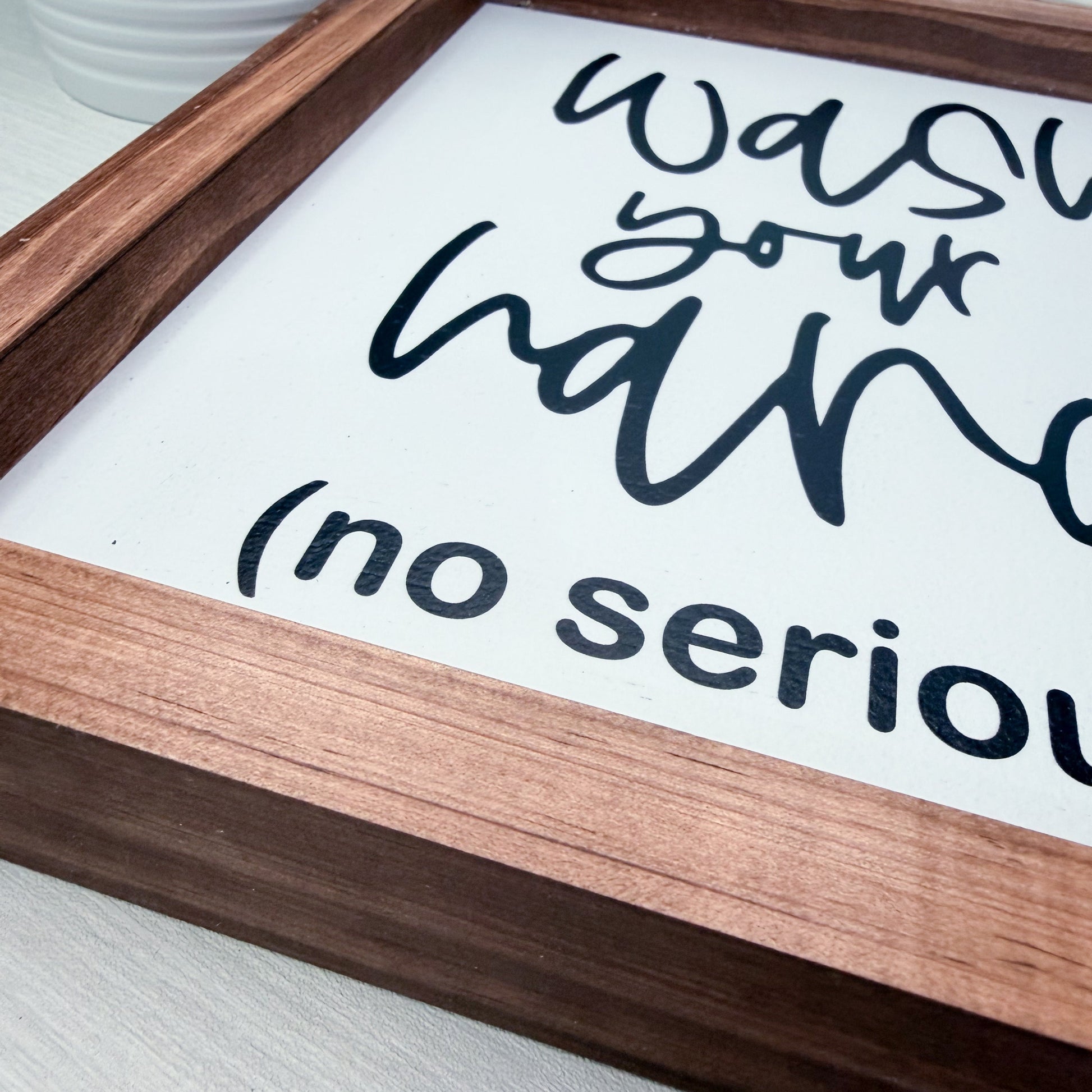 Wooden sign with text 'Was your hand' on a white background