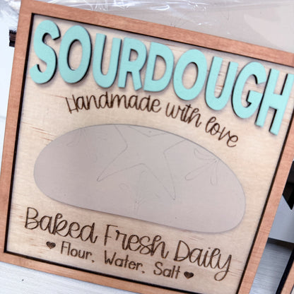 Wooden sign with 'Sourdough Handmade with Love' text and a sourdough bread shape.