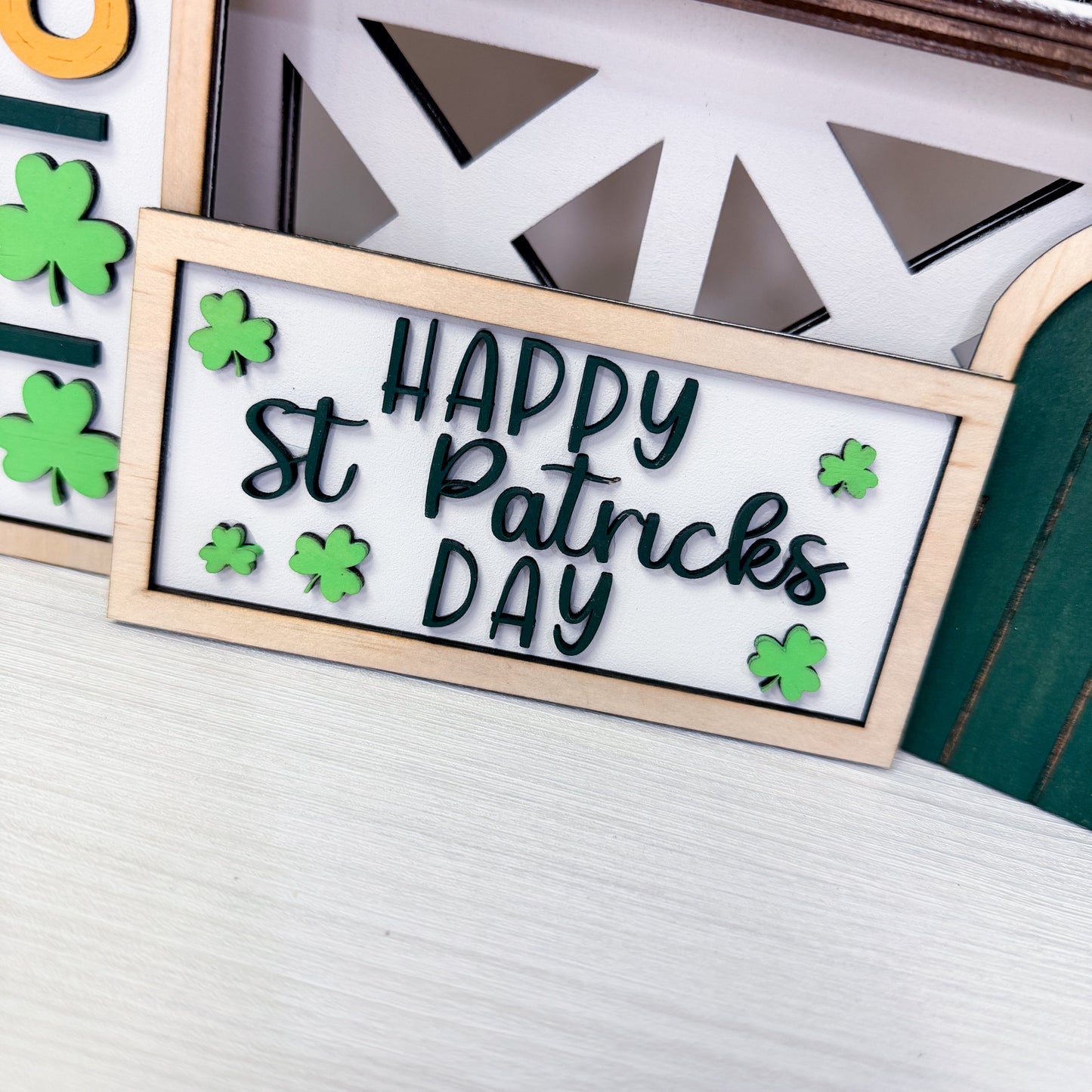 Decorative sign with 'Happy St. Patrick's Day' text and shamrock designs on a white background.