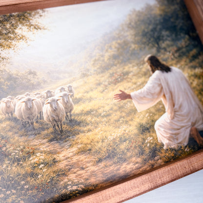Framed artwork of jesus in a white robe with sheep in a pastoral setting