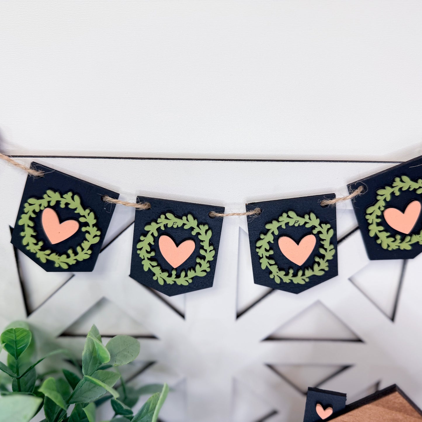 Decorative banner with heart and wreath designs on a white background
